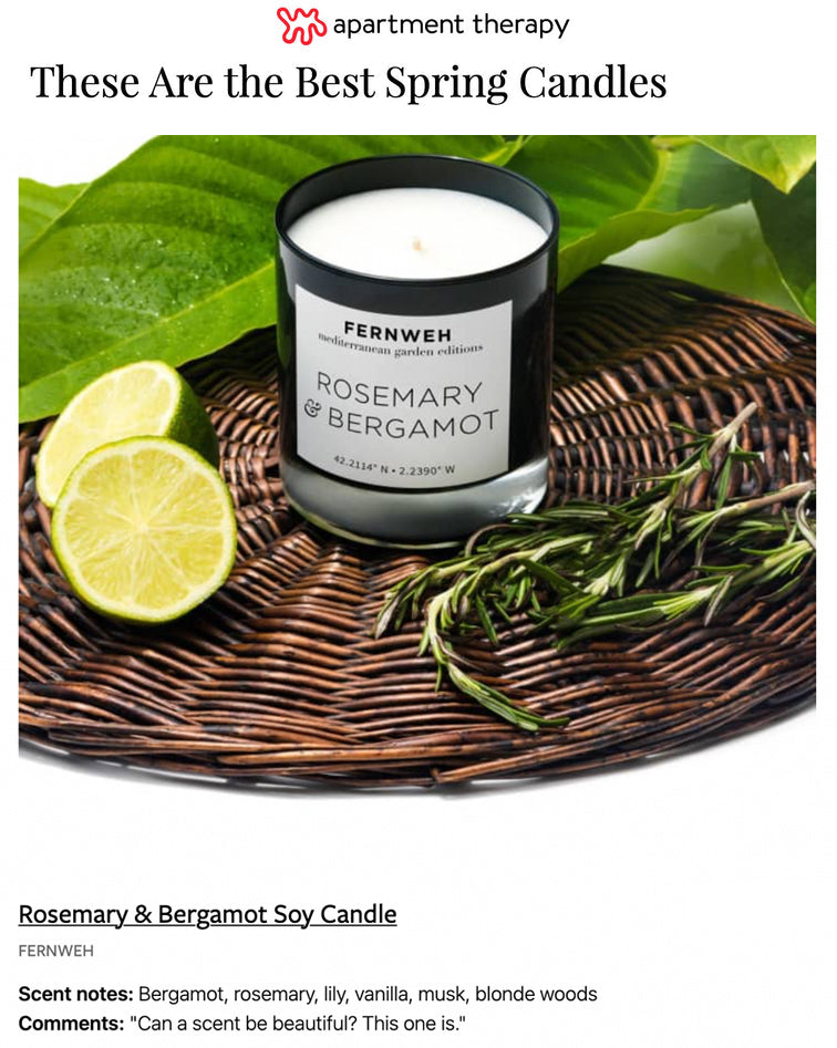 Soy candle labeled Rosemary & Bergamot on a wicker tray with lemon and rosemary