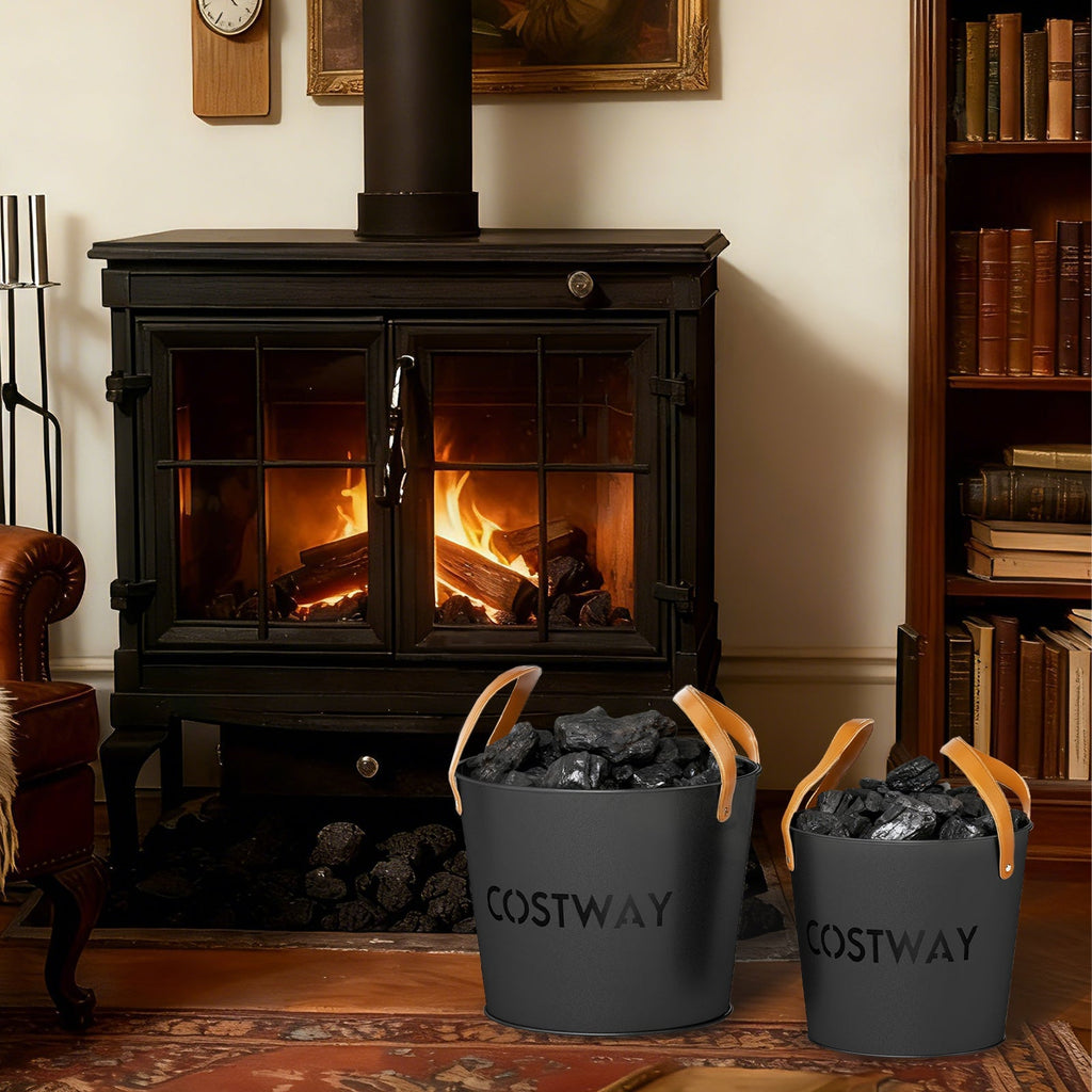 Set of 2 black metal ash buckets with tan leather handles by a fireplace
