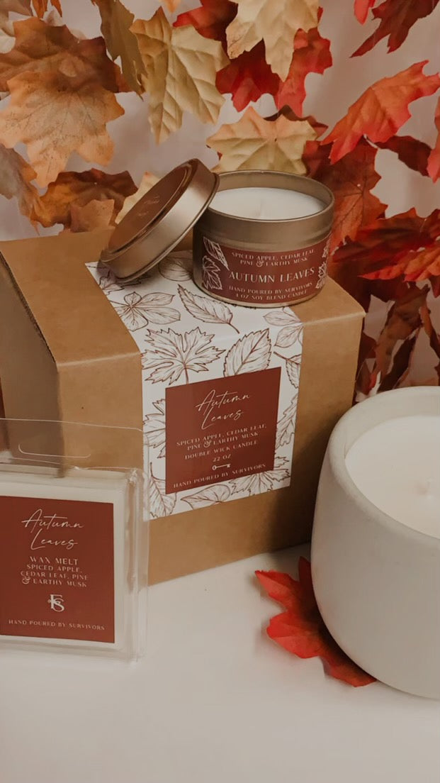 Autumn Leaves tin candle with gold lid and leaf-print label on the tin