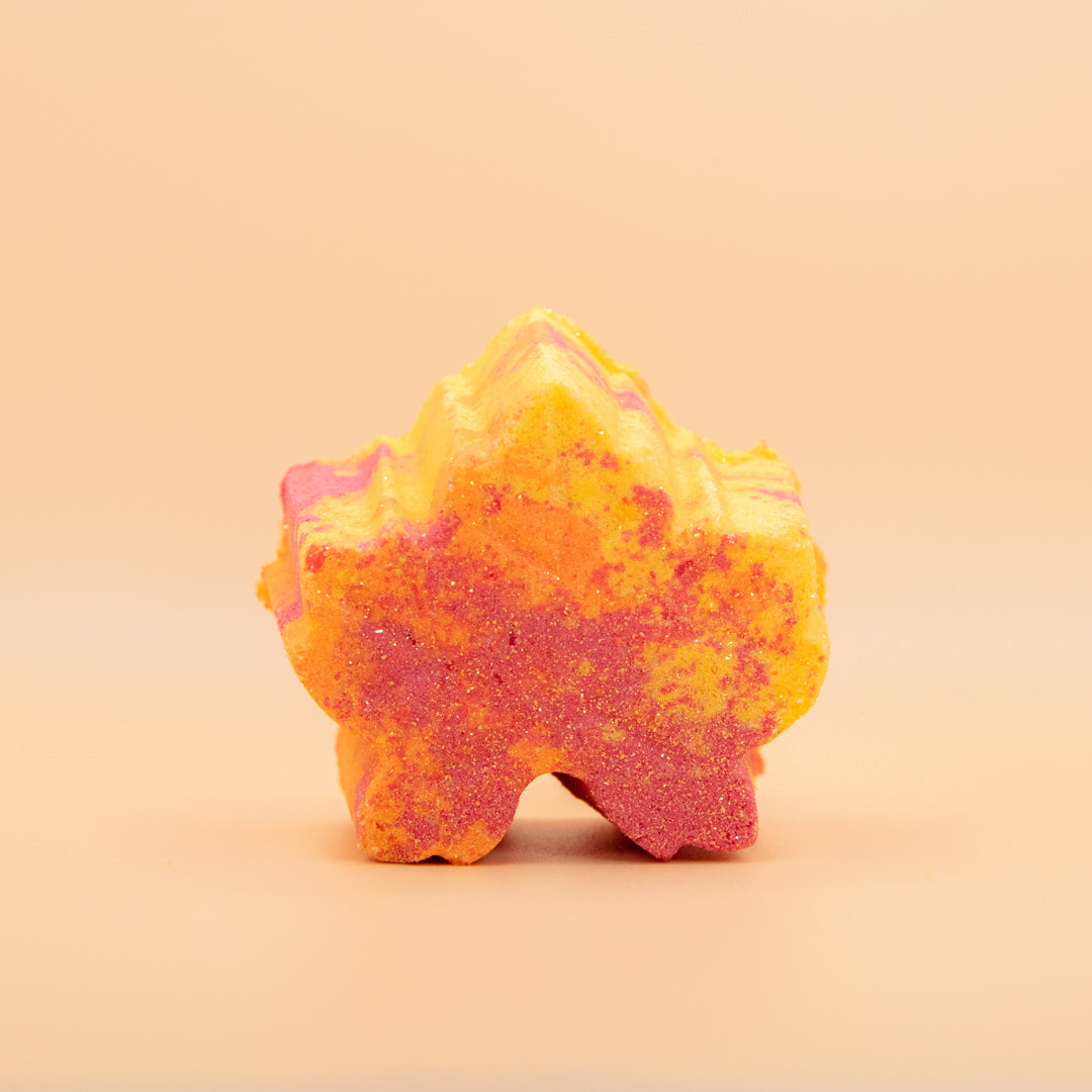 Orange glitter flower-shaped bath bomb with yellow highlights