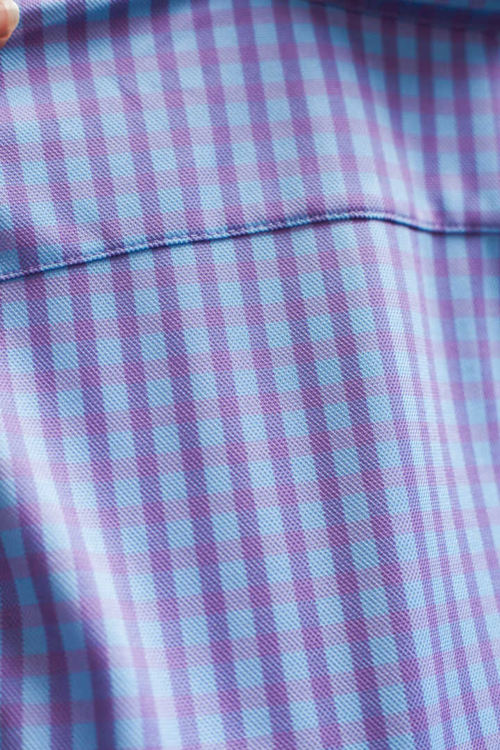 Purple and white check shirt fabric close-up with stitched seam