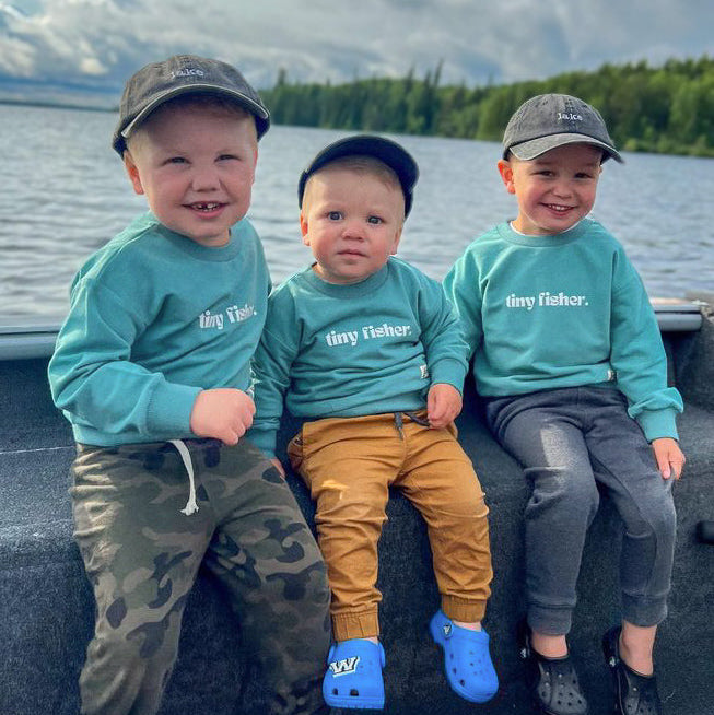 Teal crewneck pullover on three children, long sleeves with ribbed cuffs and hem.