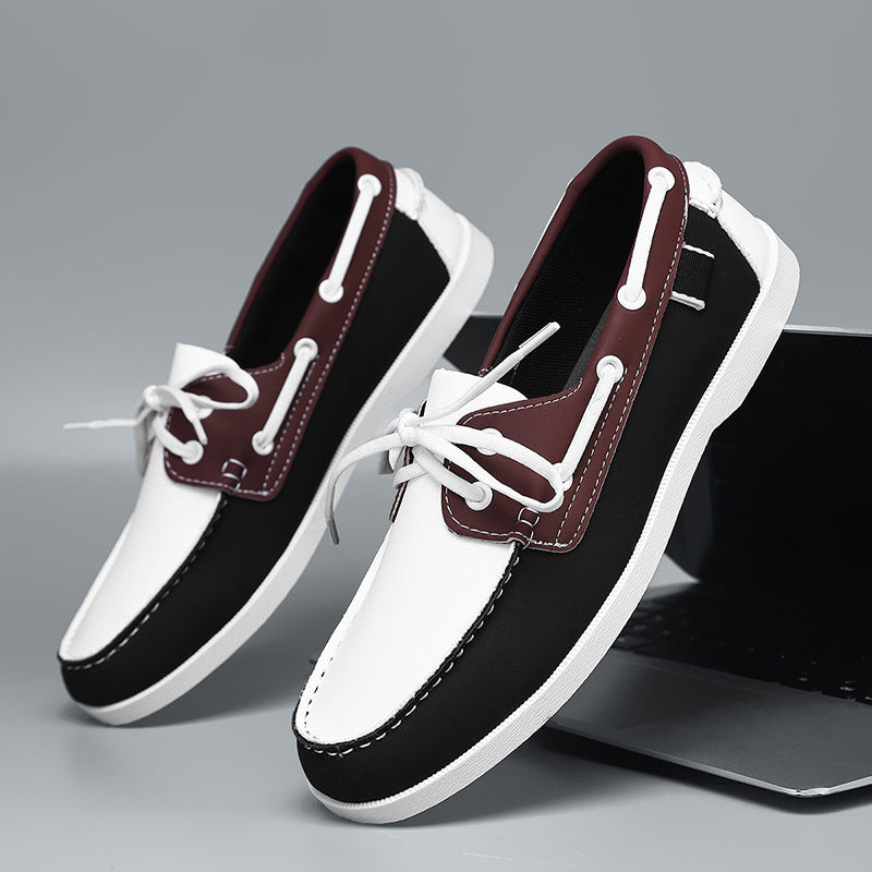 Men's black loafers with white toe panels, red-brown trim, and white laces