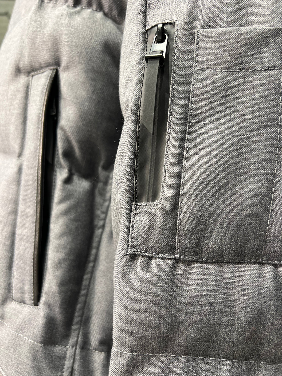 Grey coat close-up of front zipper pull and outer patch pocket