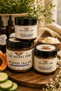 Whipped tallow body butter jars with black lids and cream on a wooden surface