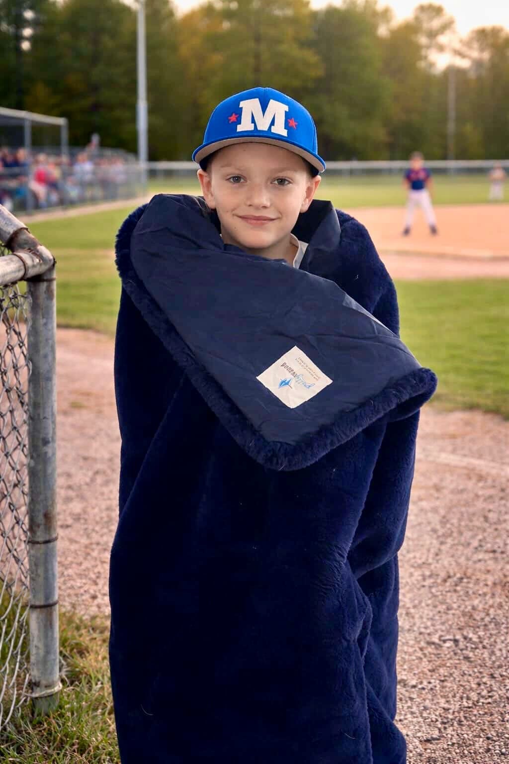 Outdoor blanket hoodie-style wrap in dark navy plush fabric.