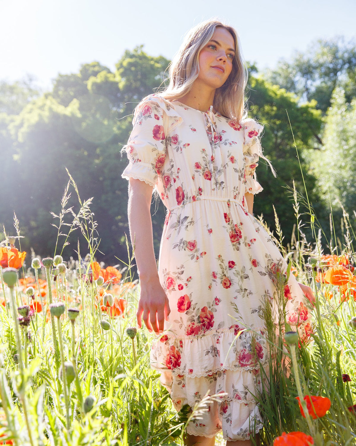 Floral tiered dress with puff sleeves and ruffled layers, cream base with pink-red flowers