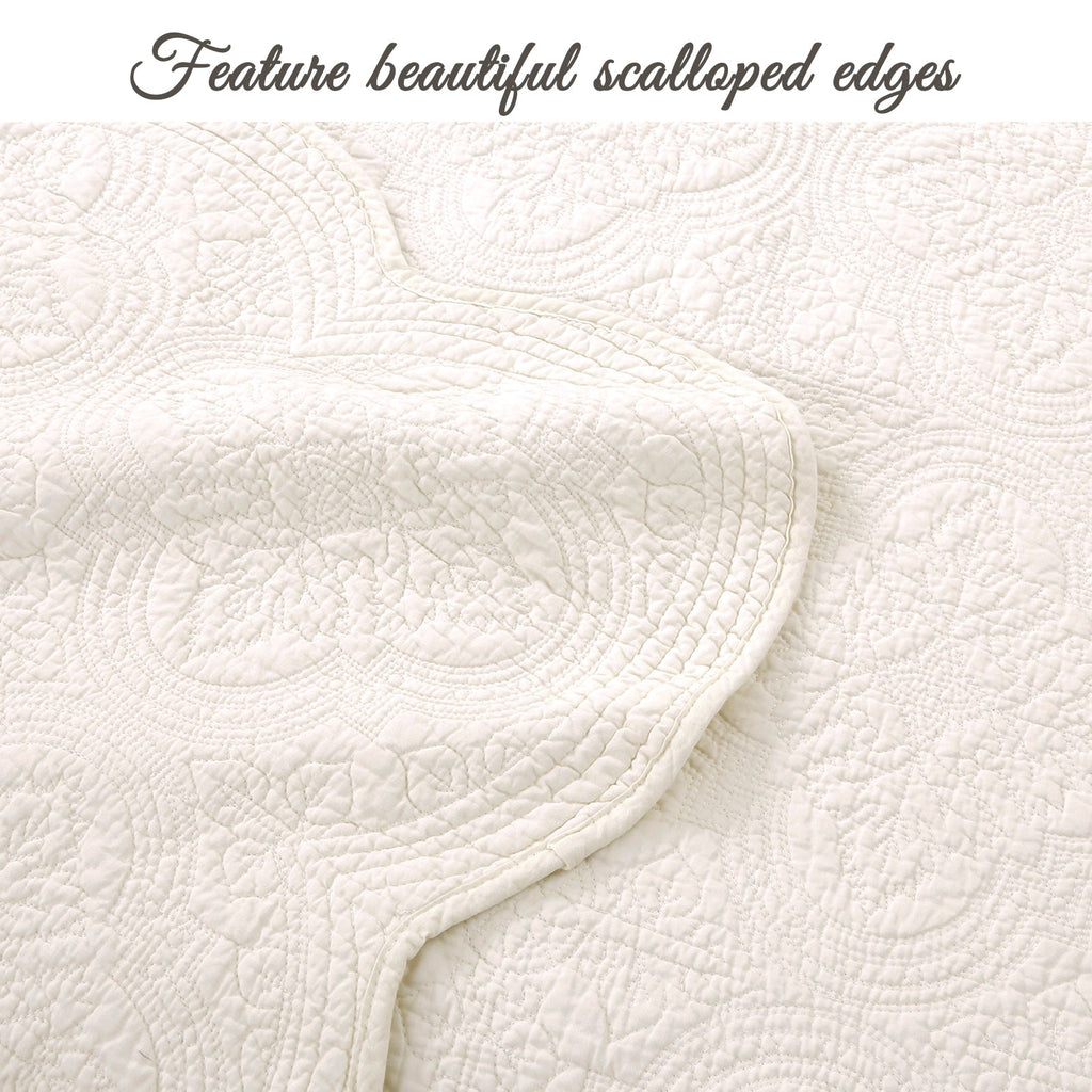 Ivory quilt detail with scalloped edges and textured medallion floral quilting