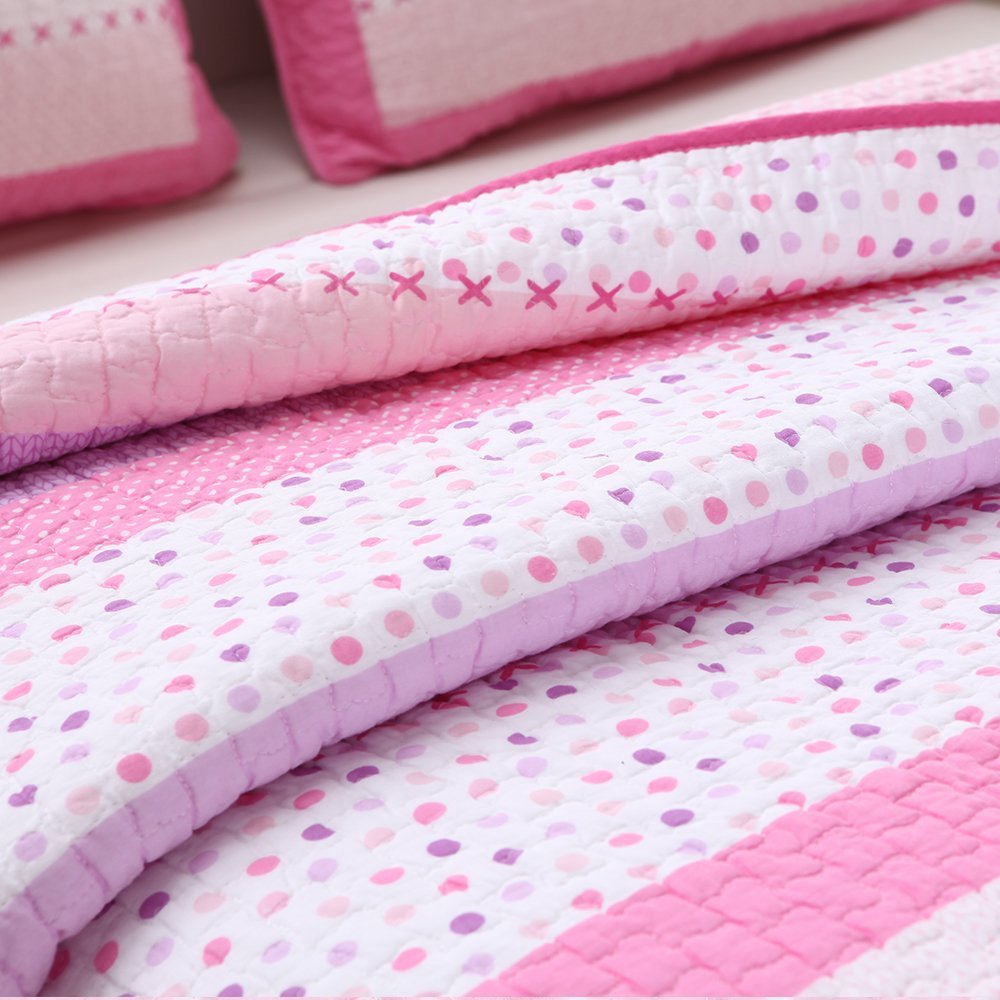 Rolled pink and white quilt layers with polka-dot and heart-pattern stitching