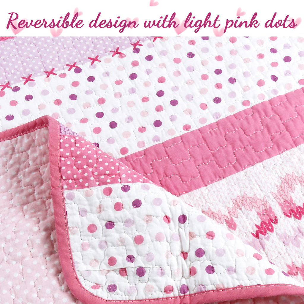 Pink polka-dot and heart-pattern reversible quilt with quilted seam edging