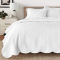 White cotton reversible quilt set with scalloped edges and medallion floral quilting