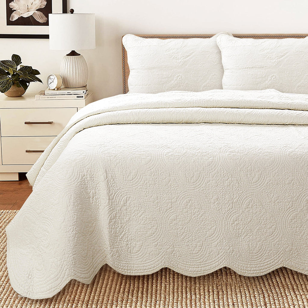Ivory reversible cotton quilt with scalloped edge and embossed medallion floral pattern