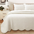 Ivory reversible cotton quilt with scalloped edge and embossed medallion floral pattern