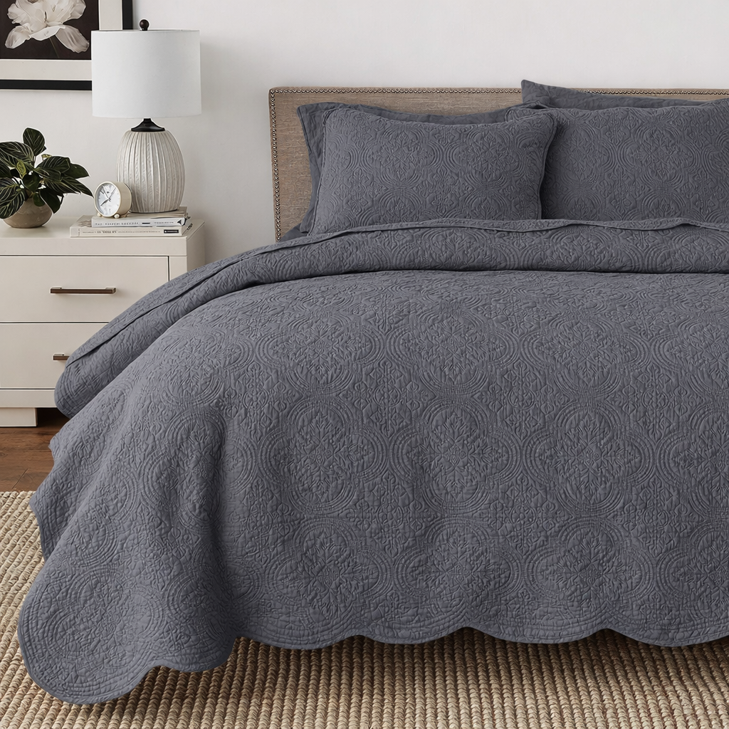 Gray quilt bedding set with reversible medallion quilting and scalloped bed skirt edge