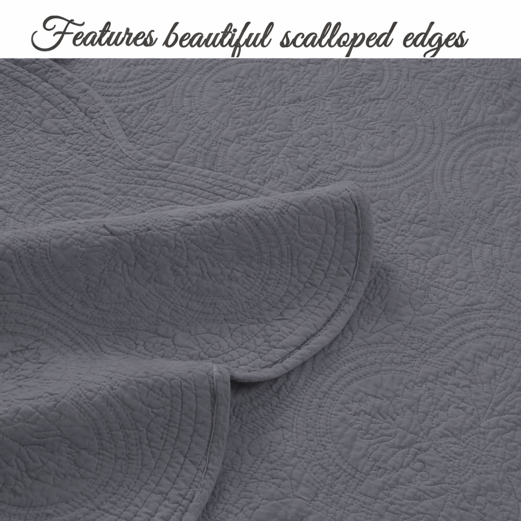 Gray quilt and pillow showing scalloped edges and textured medallion quilting detail