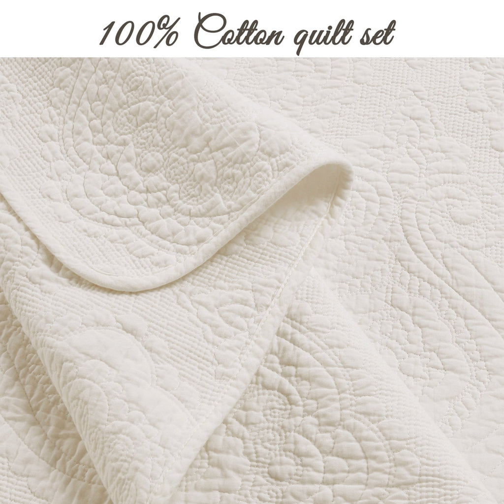 Ivory cotton quilt with dense textured quilting and curved medallion motifs