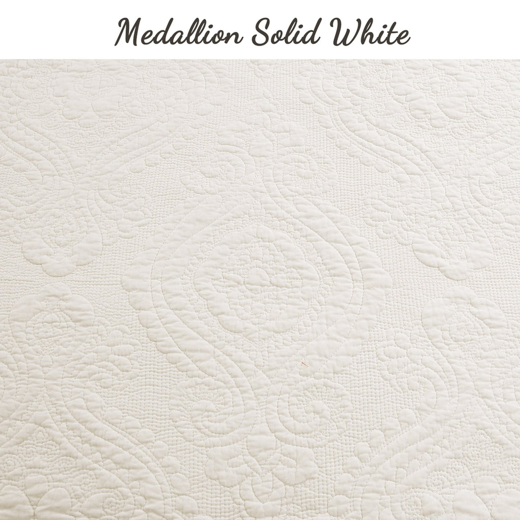 Solid white quilt fabric with repeating medallion quilting pattern