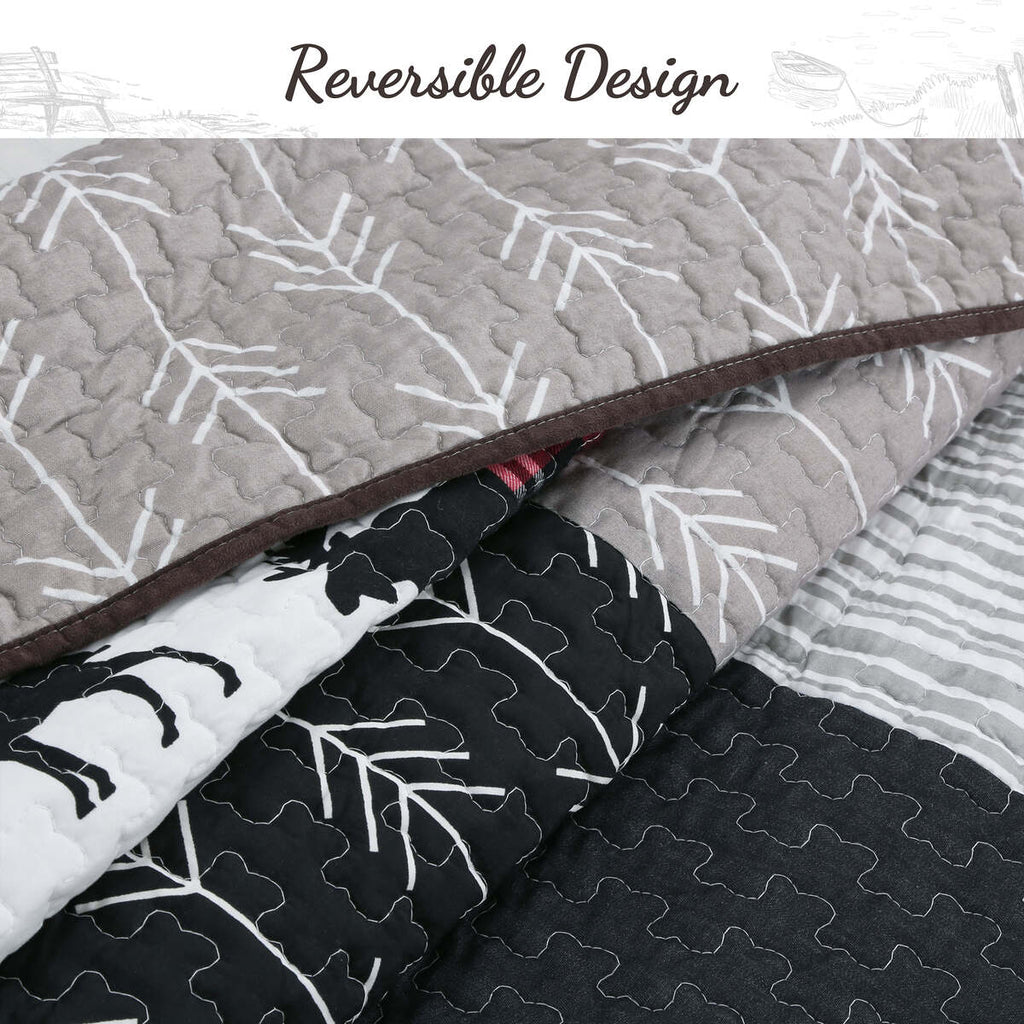 Reversible quilt with gray tree pattern and black deer/tree panel, brown binding