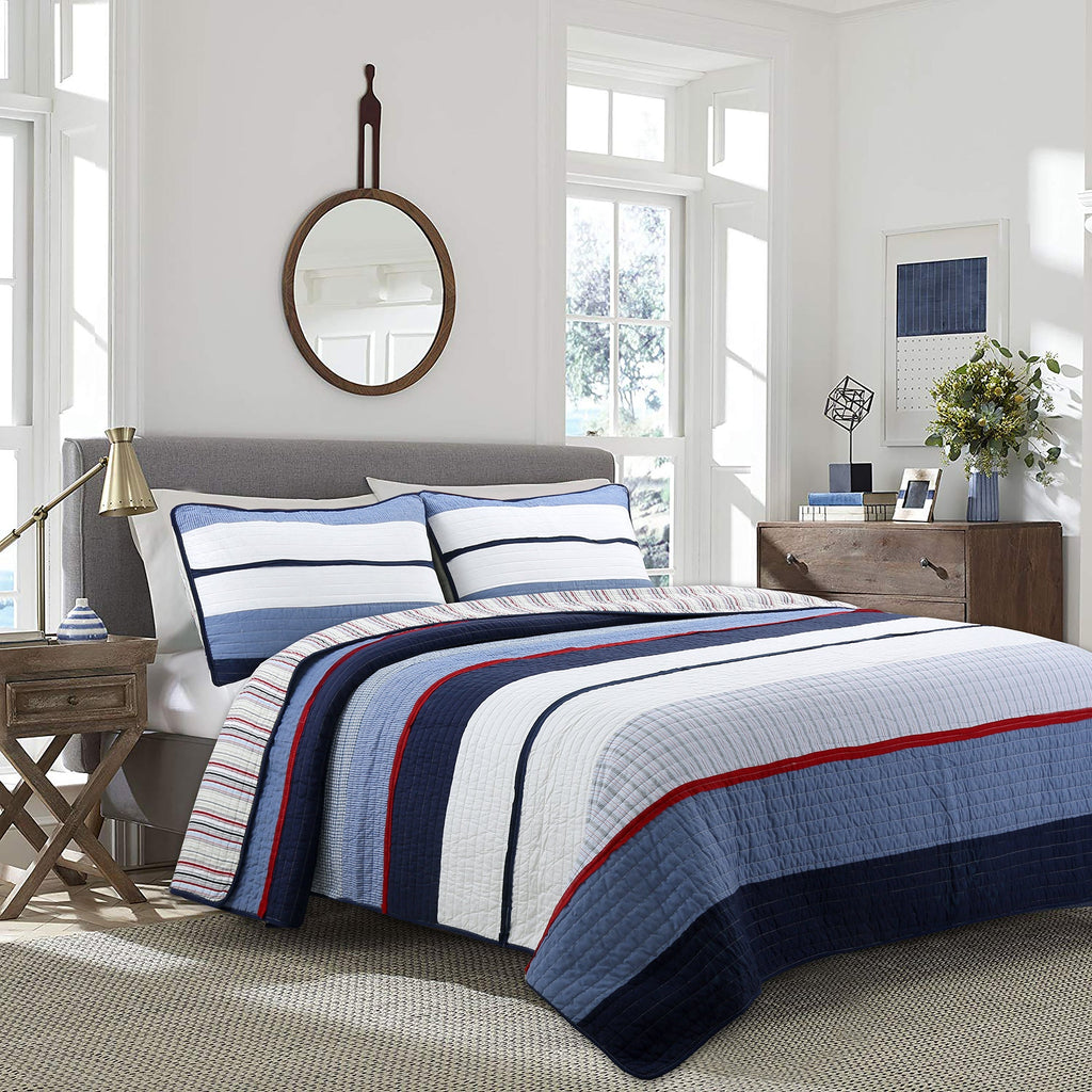 Reversible quilt set with blue and white striped quilt, navy border, and red trim