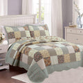 Reversible patchwork cotton quilt with scalloped edges and floral blocks in teal and cream