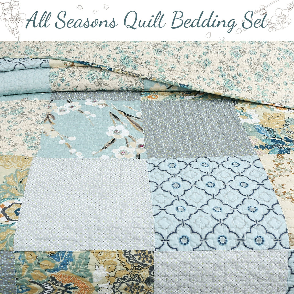 Patchwork quilt laid flat showing quilted squares in light blue, cream, and golden accents