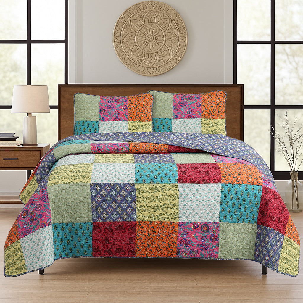 Bright patchwork quilt set on bed with matching pillow shams and colorful floral squares