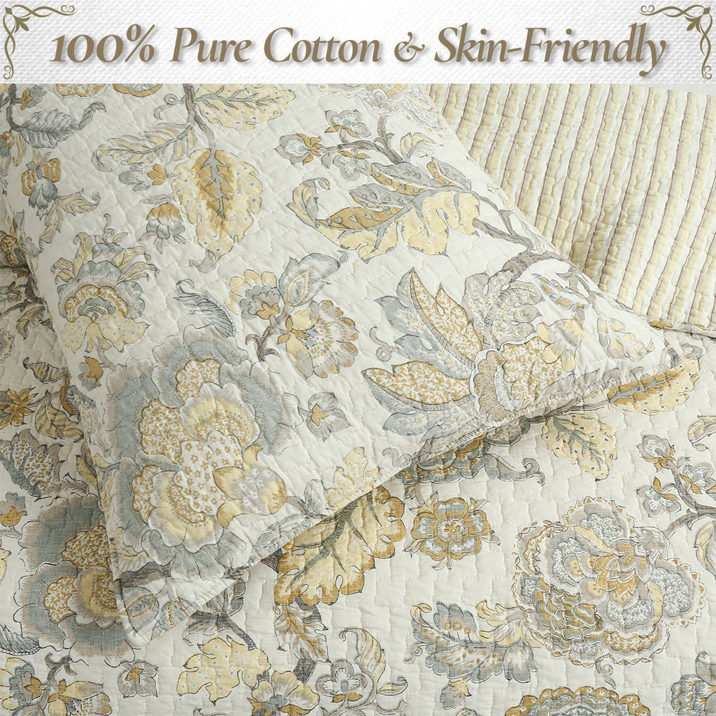 Cotton quilt close-up with botanical floral print in cream, gray, and gold tones