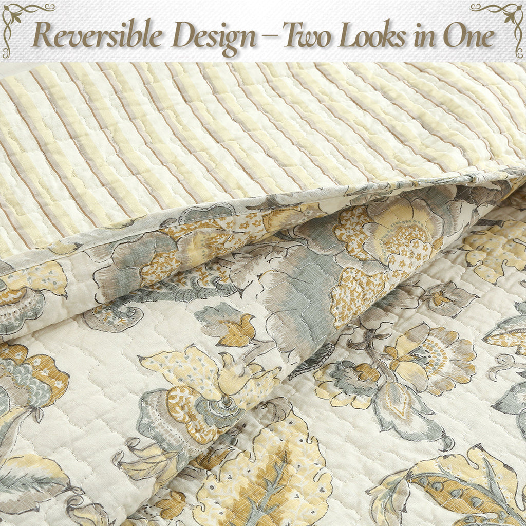Reversible quilt showing light side with floral print, cream with muted gray and gold
