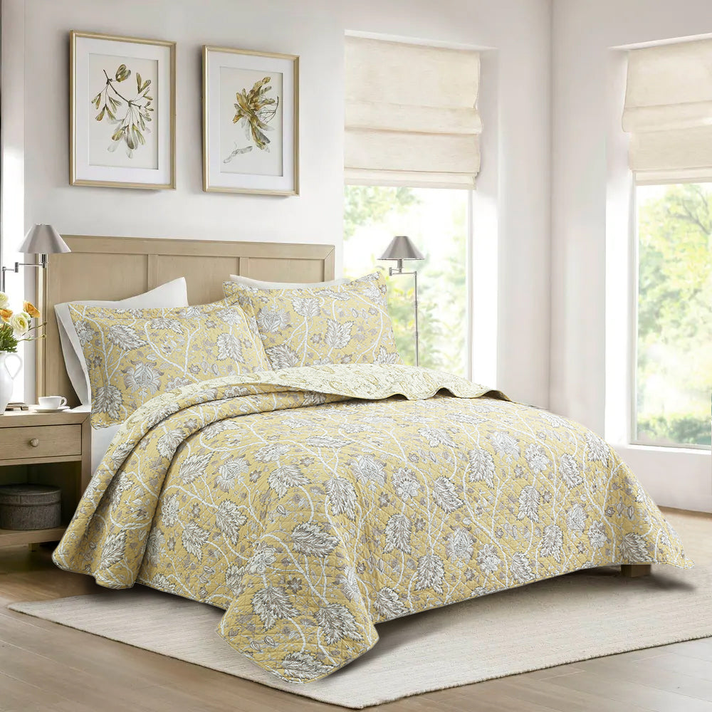 Cotton quilt bedding set on bed with light yellow floral pattern and pillow shams