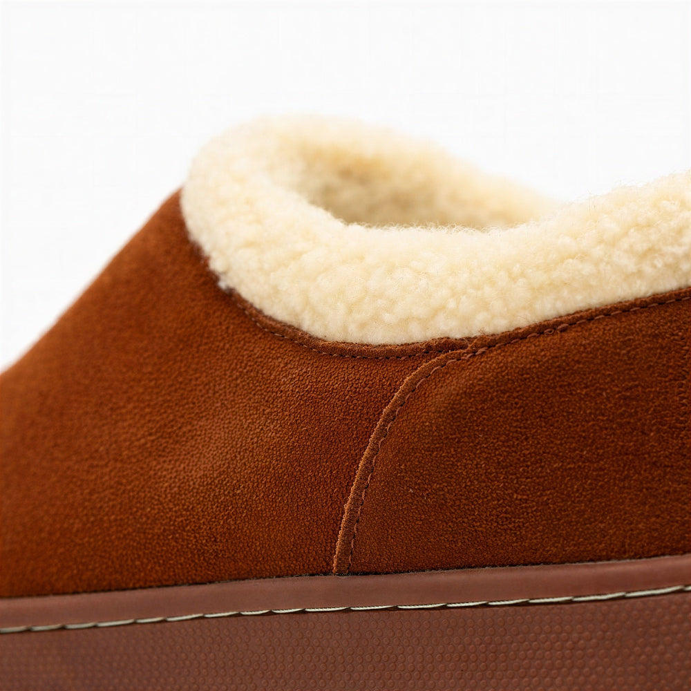 Close-up of honey-brown suede Ashton slipper with cream sherpa trim and seam detail