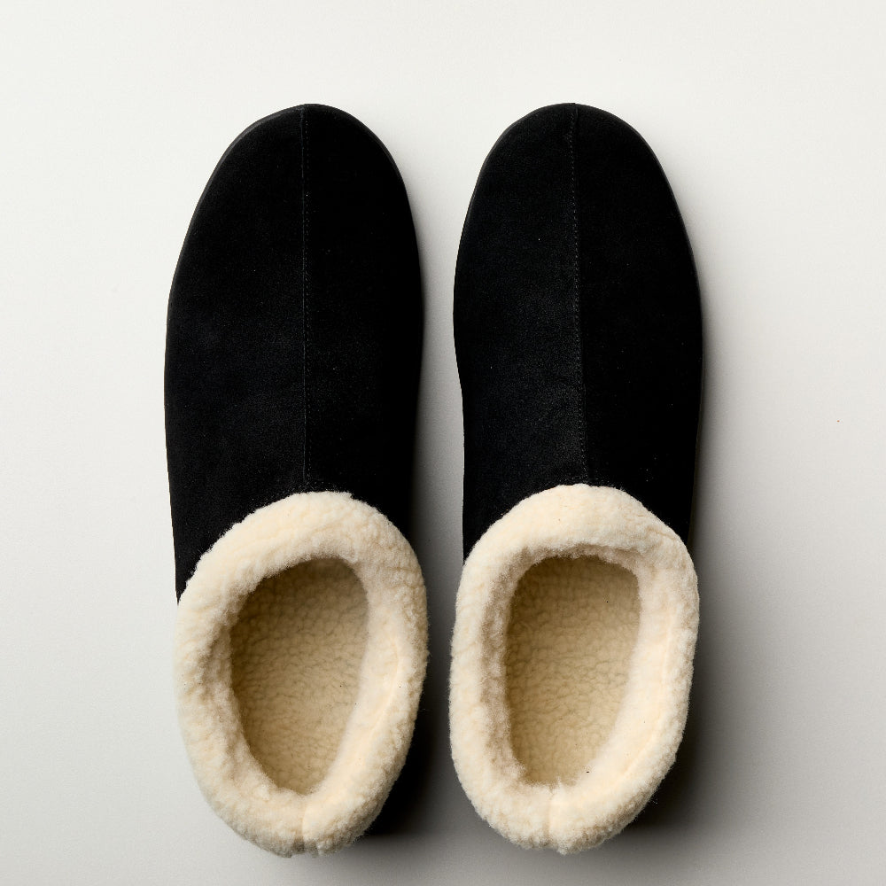 Pair of men's black slip-on slippers with cream fleece lining