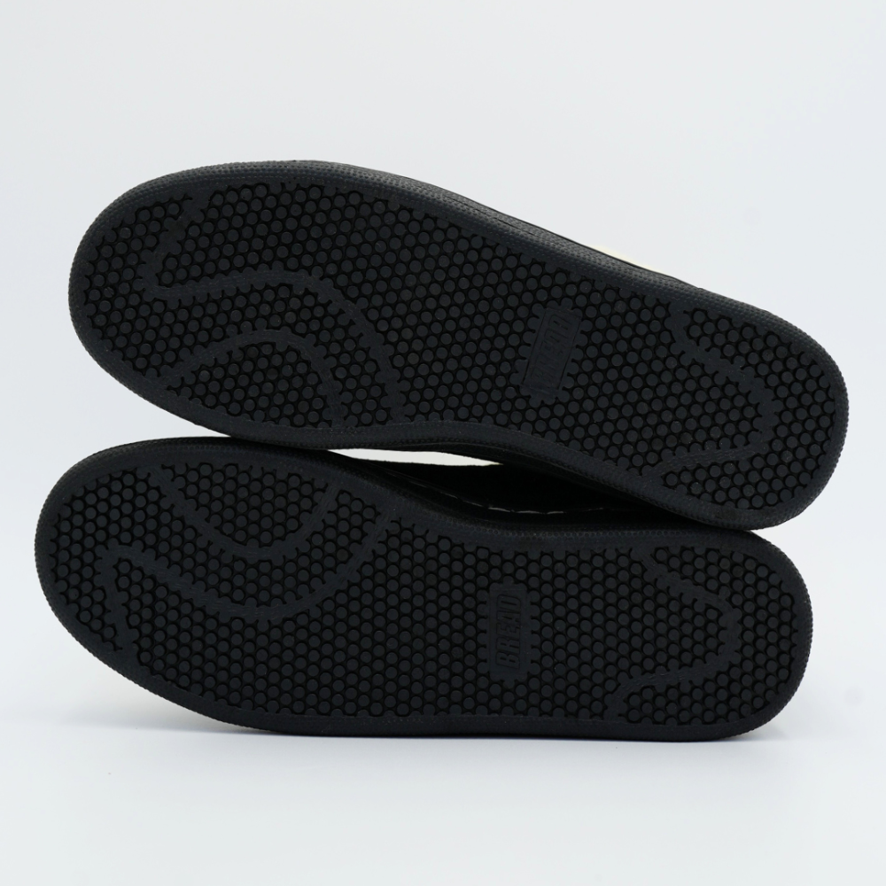 Outsoles of men's black slippers with textured traction pattern