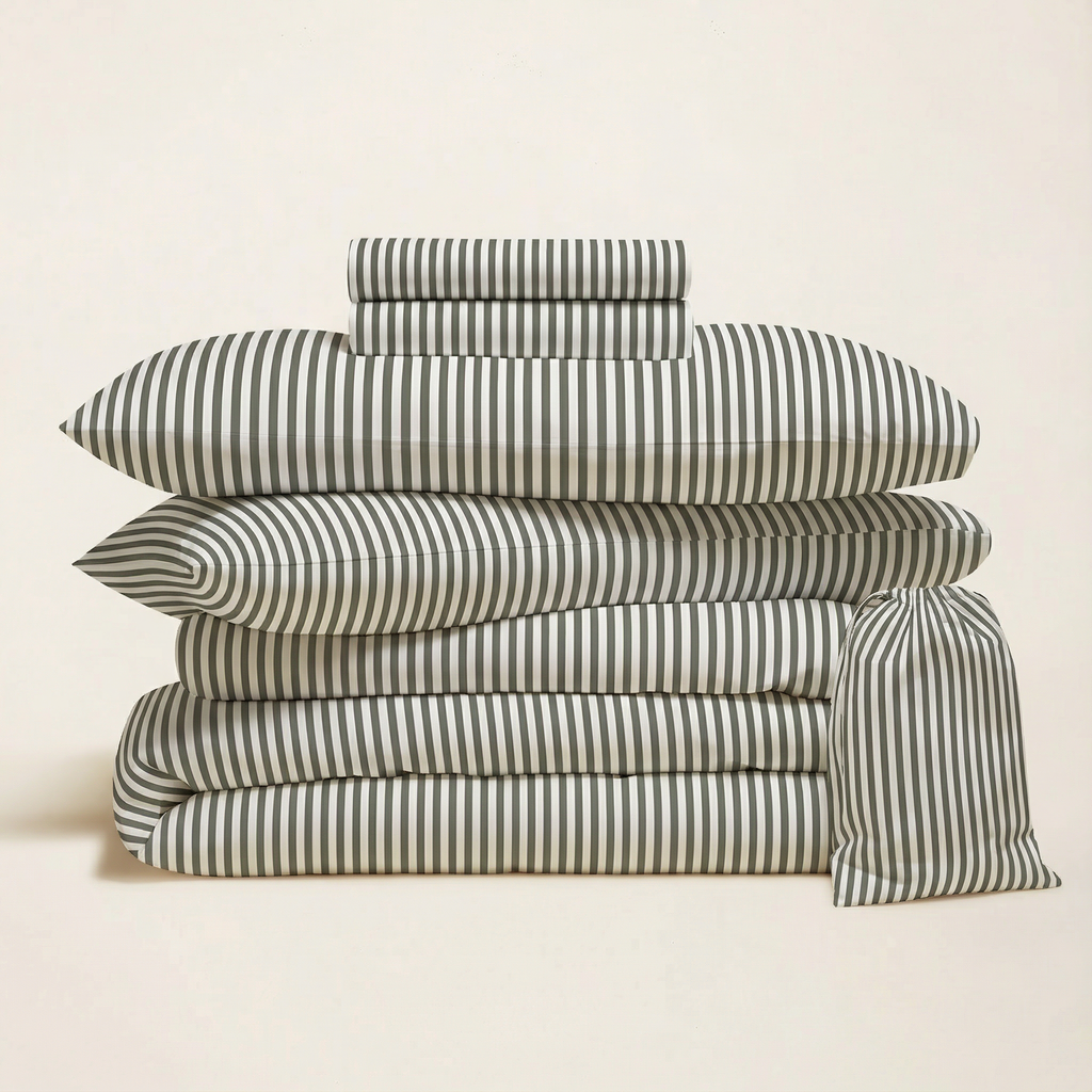 Stacked sateen bedding bundle with black-and-white vertical stripe pillows.