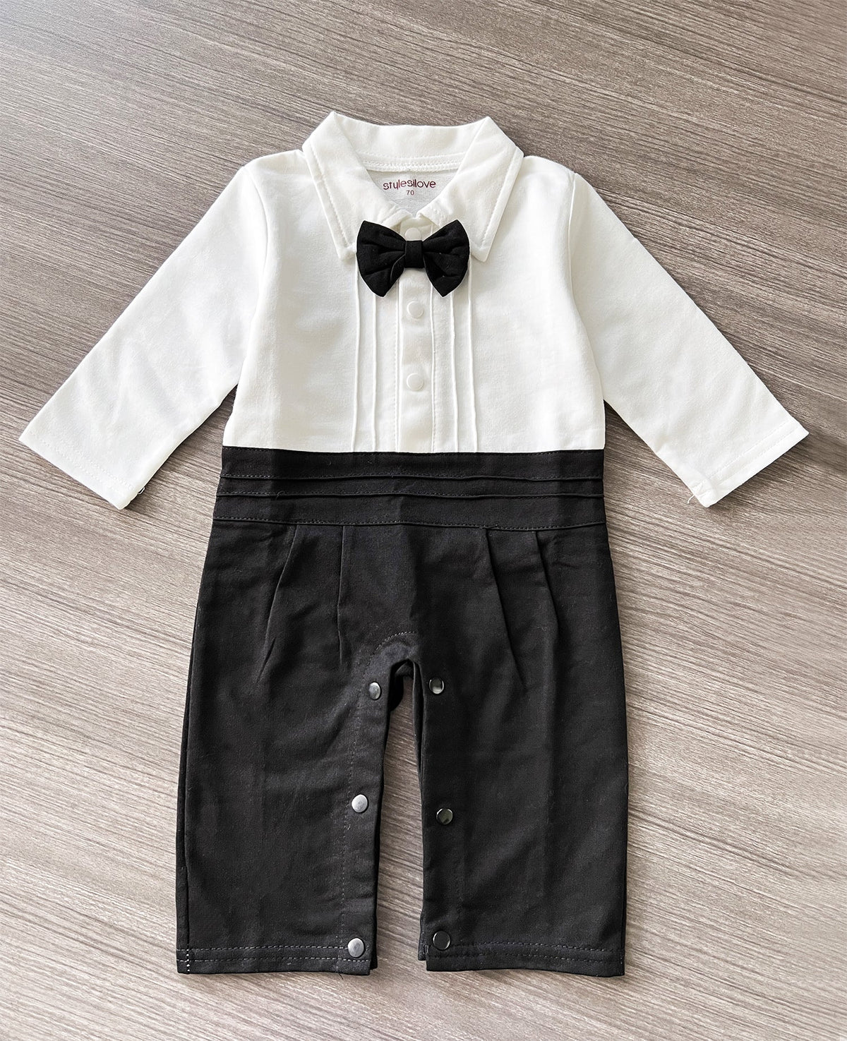 White-and-black baby romper with bow tie, button placket, and tailored front