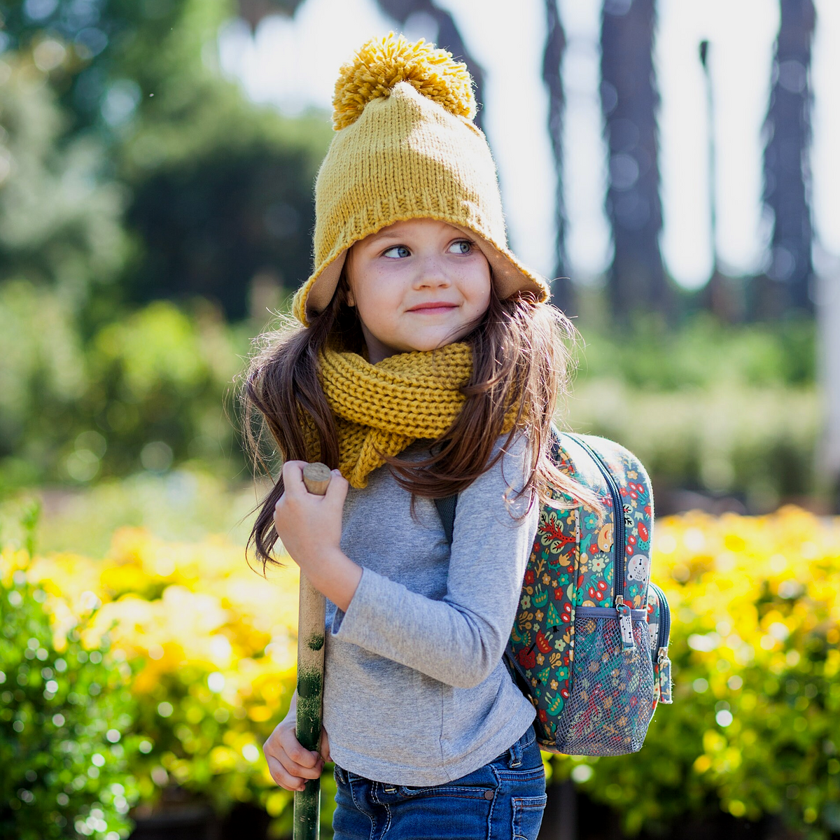 Children's navy mini backpack with forest animal print worn with straps