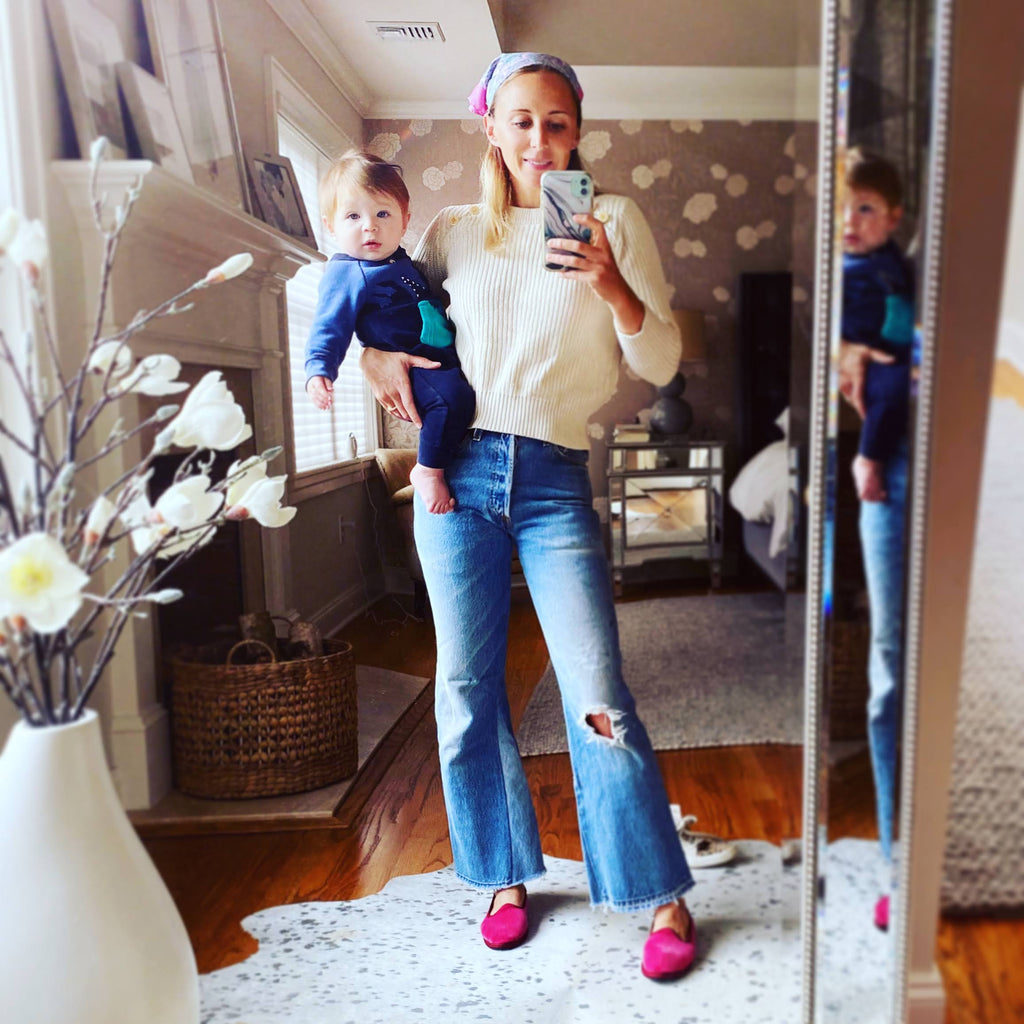 Unisex pink slip-on slippers with low sole and contrast piping, worn with blue jeans