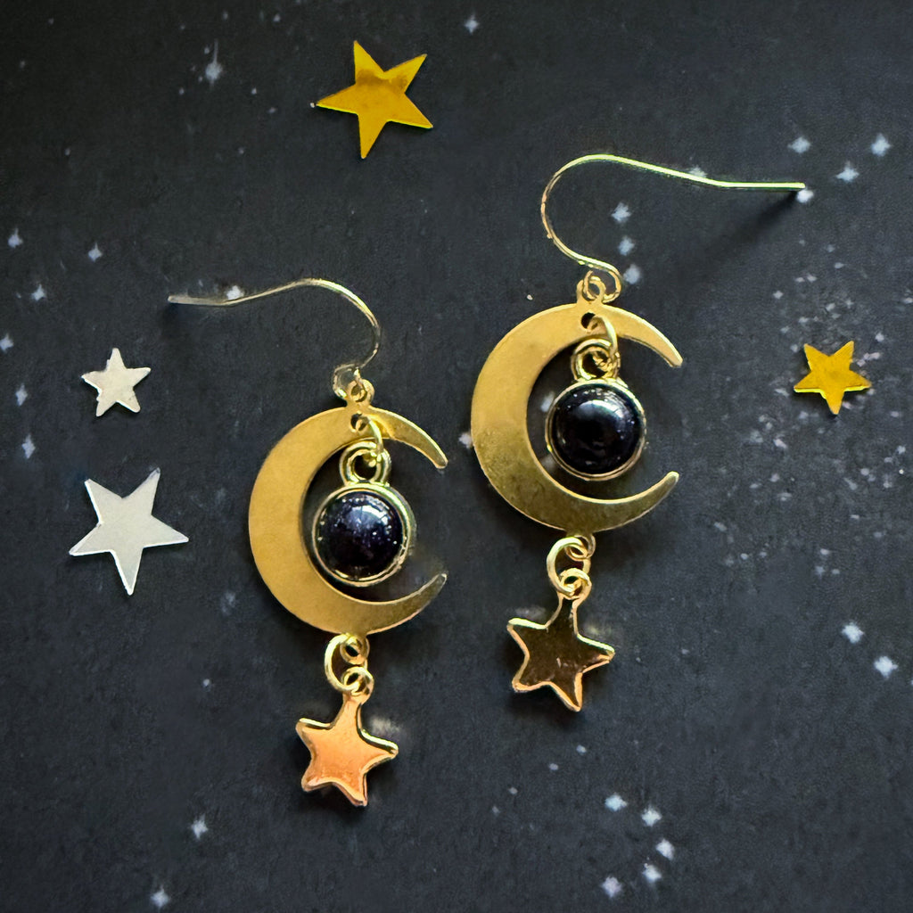 Gold crescent moon earrings with dark blue stones and dangling star charms