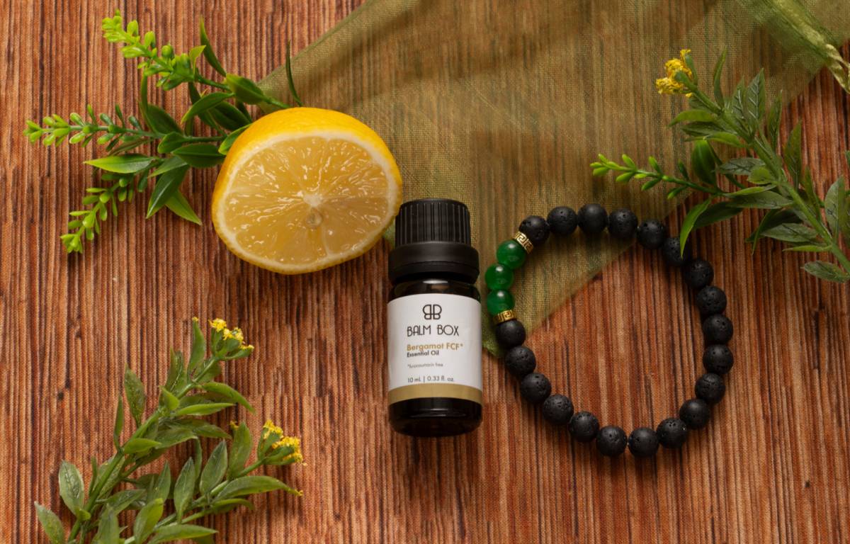 Botanical balm bottle with half orange and beaded bracelet