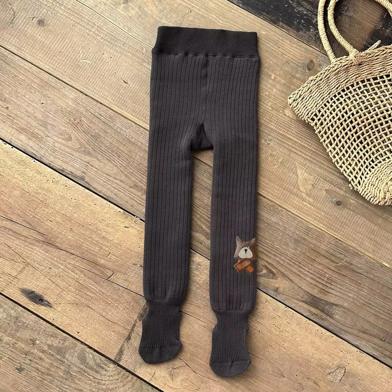 Black ribbed footed leggings with bear patch on the ankle, laid flat