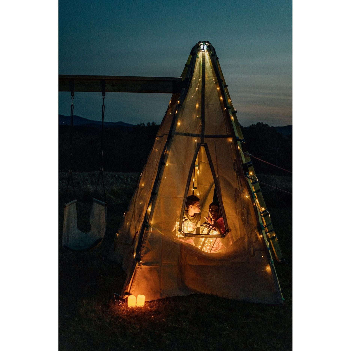 Solar string lights on a outdoor teepee tent at night with warm LED glow