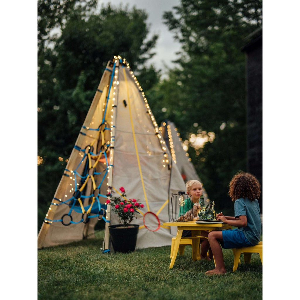 Solar string lights outlining a teepee tent with warm LED points in trees