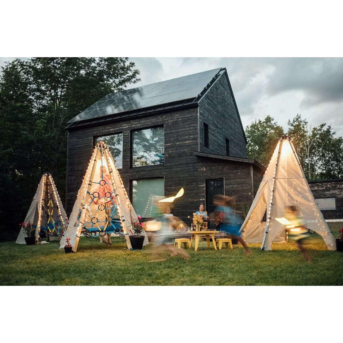Solar string light kits on multiple teepee tents with warm glowing LEDs