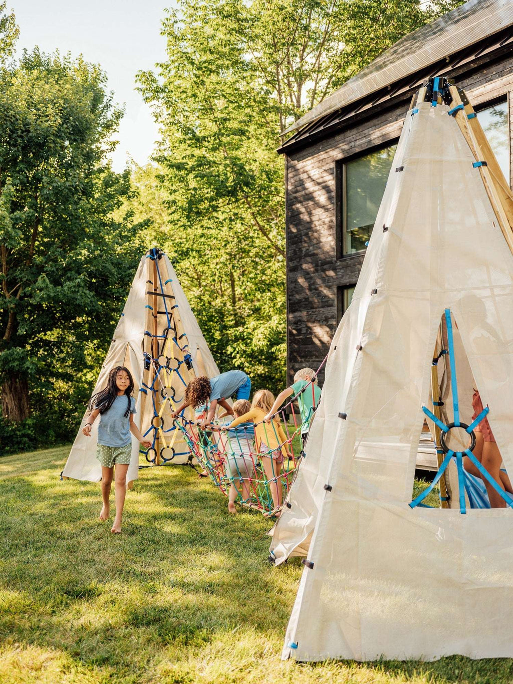 Rope suspension bridge net draped between posts with colorful side cords