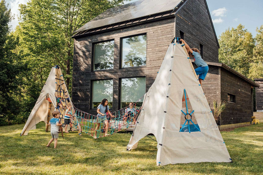 Multicolor rope suspension bridge with canvas tents at outdoor play area