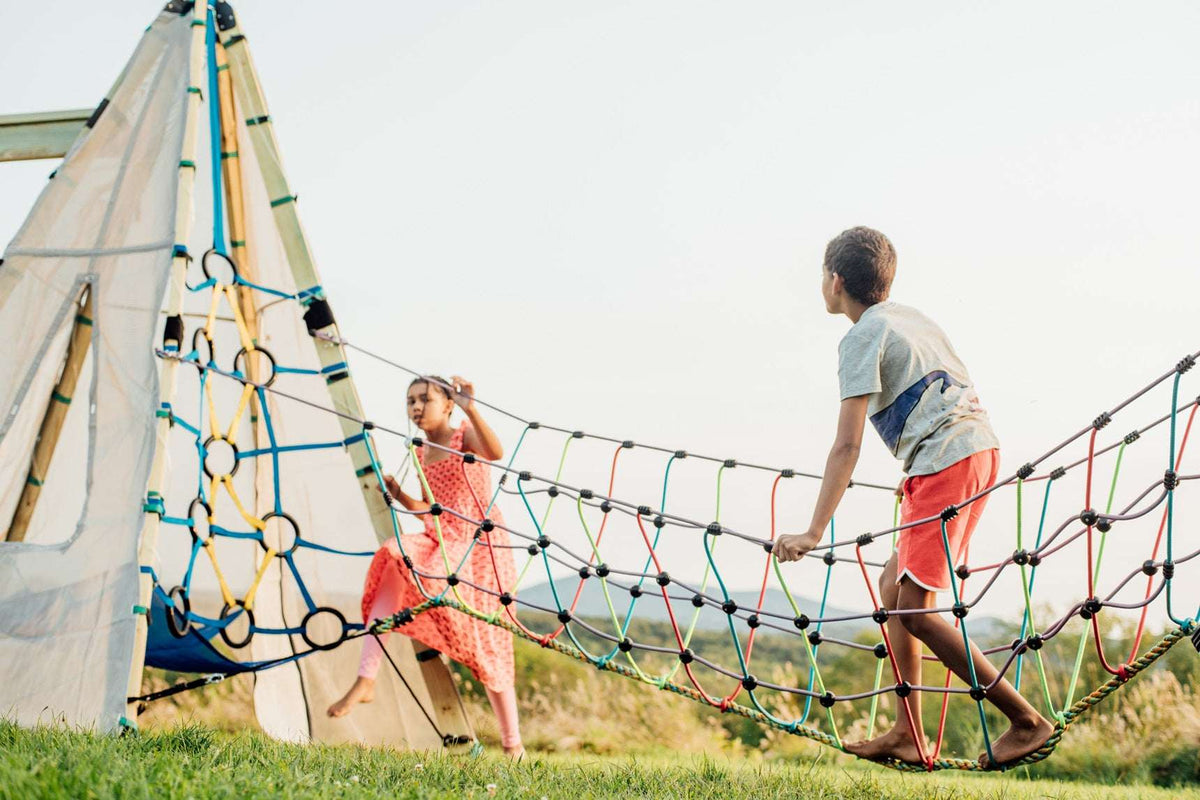 Rope suspension bridge with multicolor knots and braided side ropes outdoors