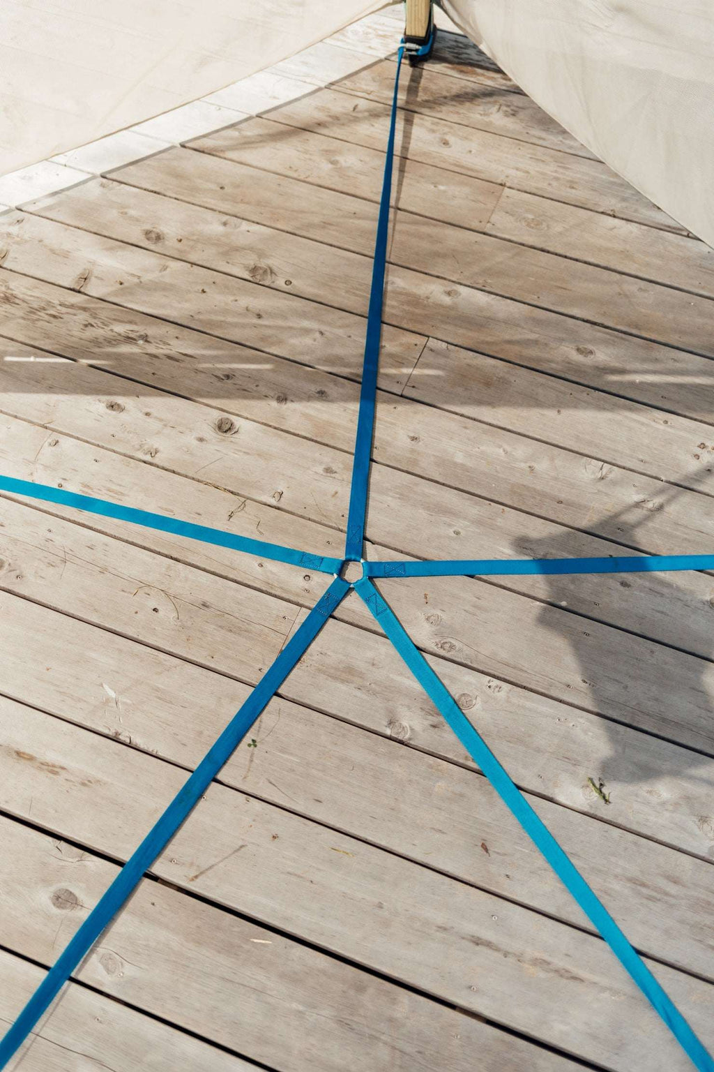 Canvas teepee top with blue tie straps and wooden frame beams