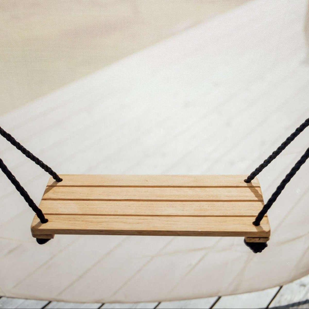 Bijou Rest hanging wooden swing with black rope, straight-on view