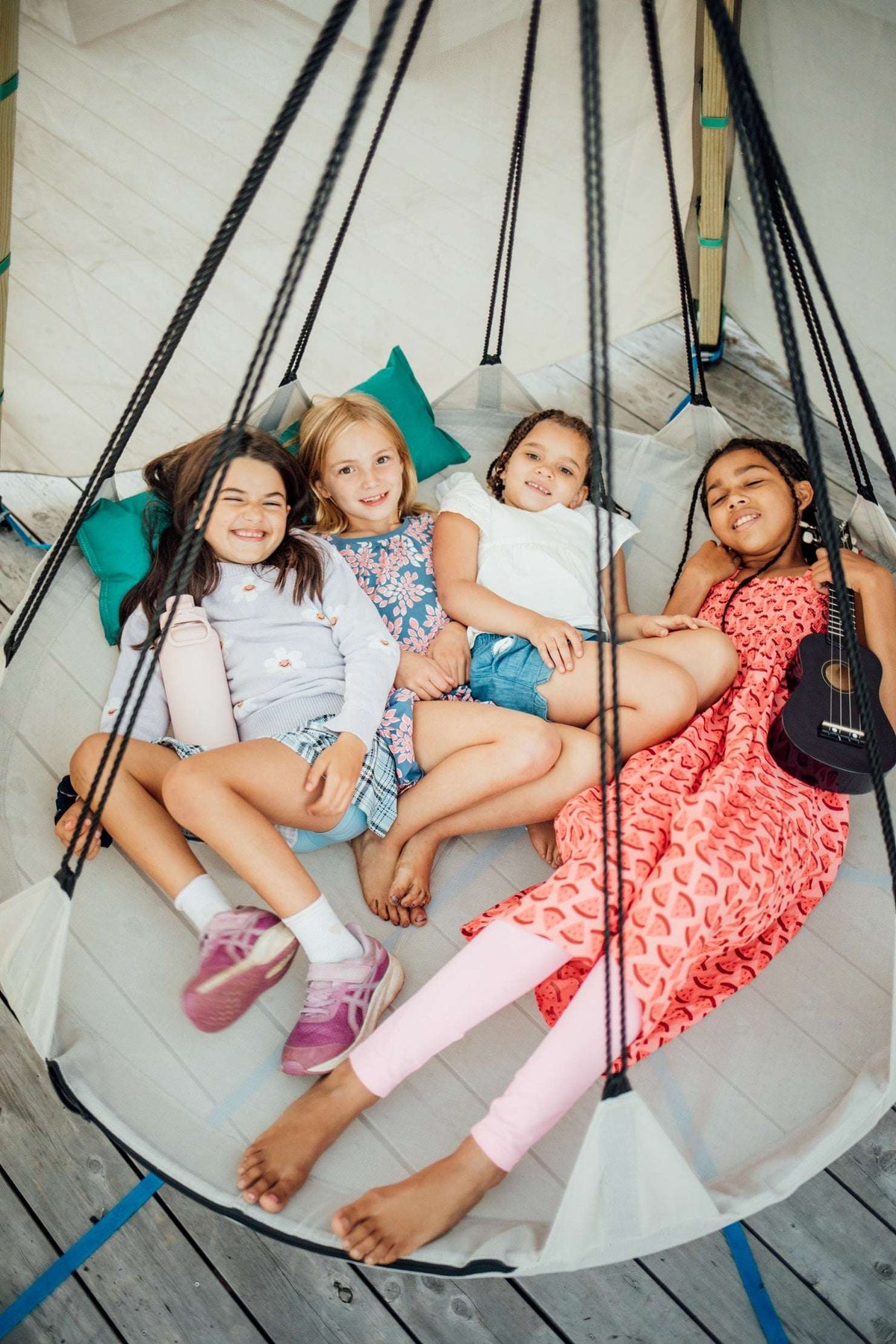 Hanging mesh hammock nest with four black suspension ropes and round fabric seat