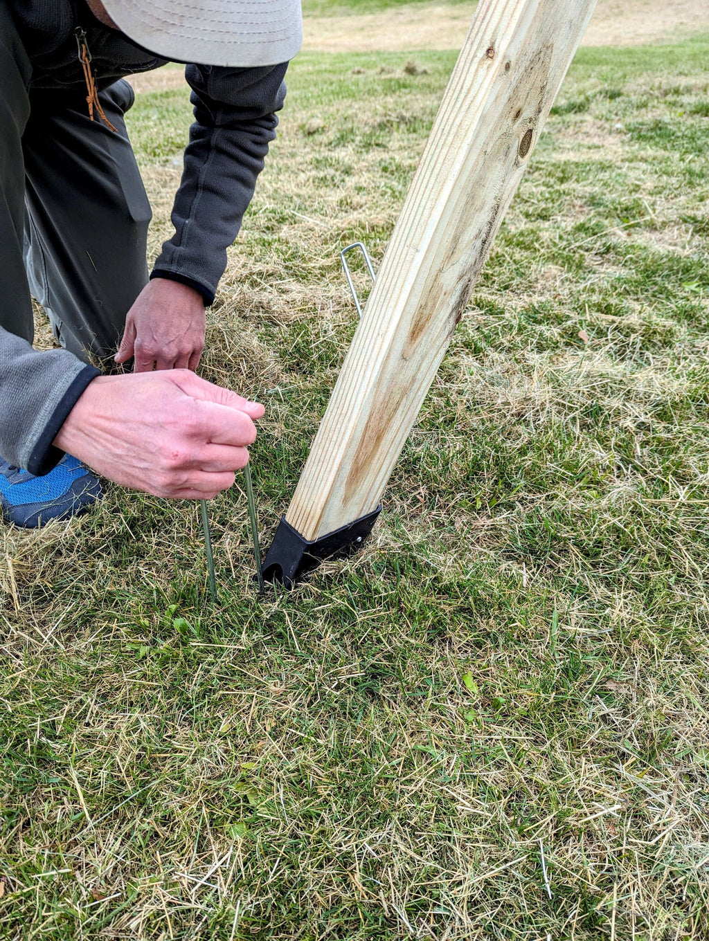 Swing arm adaptor near the base securing a wooden playset support beam
