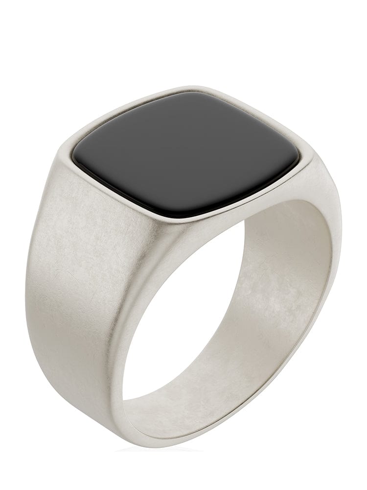 Black onyx cushion signet ring in silver-tone metal band with dark oval stone top.